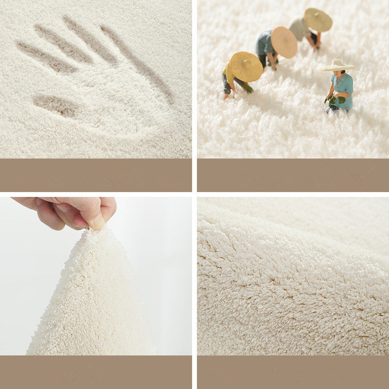 Close-up grid of the rug's soft plush pile showing texture, hand imprint, and hand-tufted detail