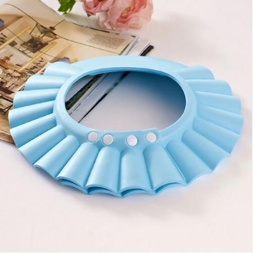Blue baby shampoo cap with a pleated waterproof brim and four white snap adjusters for head size