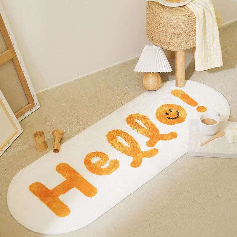Oval bedroom rug with an orange 'Hello!' text design styled with a lamp and coffee tray