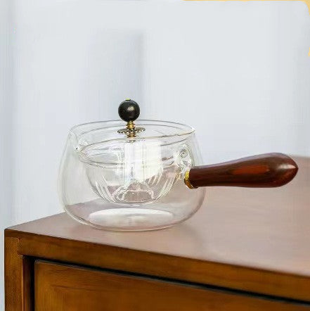 Semi-automatic rotating teapot brewing loose leaf tea on a table