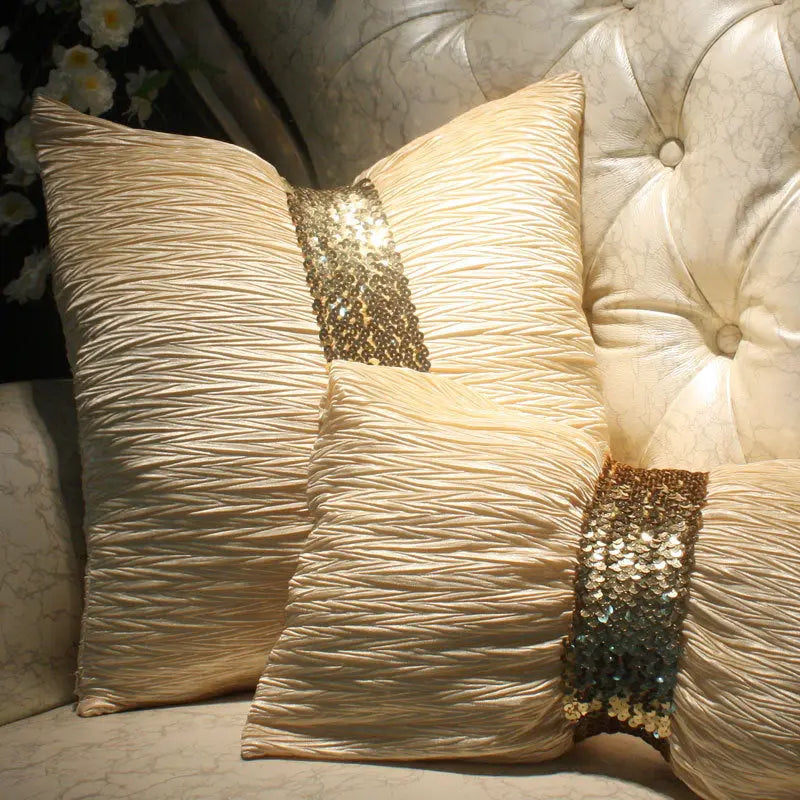 Bowknot throw pillow cushions in cream and gold sequin styled on a chair