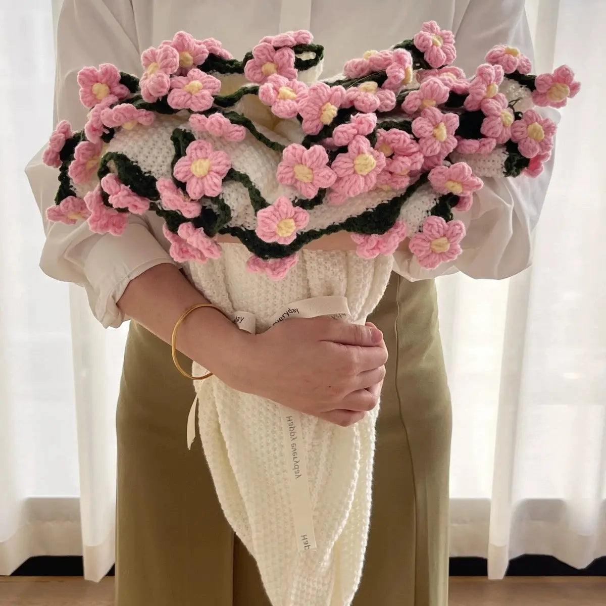 Floral woven cotton blanket folded into a pink flower bouquet design