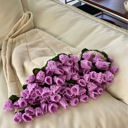 Floral woven cotton blanket folded into a purple flower bouquet, held on a couch