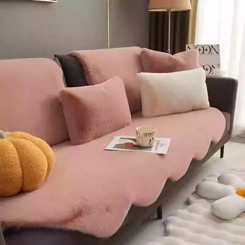Creamy plush throw styled on a pink sofa with a pumpkin decor accent