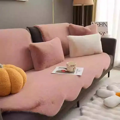 Creamy plush throw styled on a pink sofa with a pumpkin decor accent
