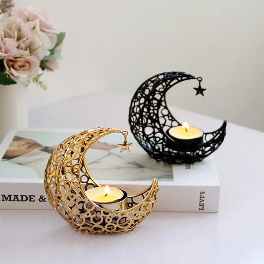 Gold and black crescent moon metal tealight candle holders styled with fresh flowers and a lit candle