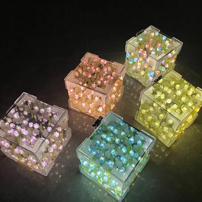 Five DIY tulip mirror night light cubes in different glowing colors grouped together