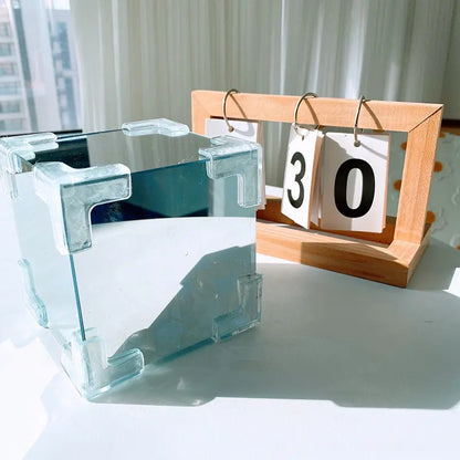 White DIY tulip mirror night light cube styled on a desk with a calendar