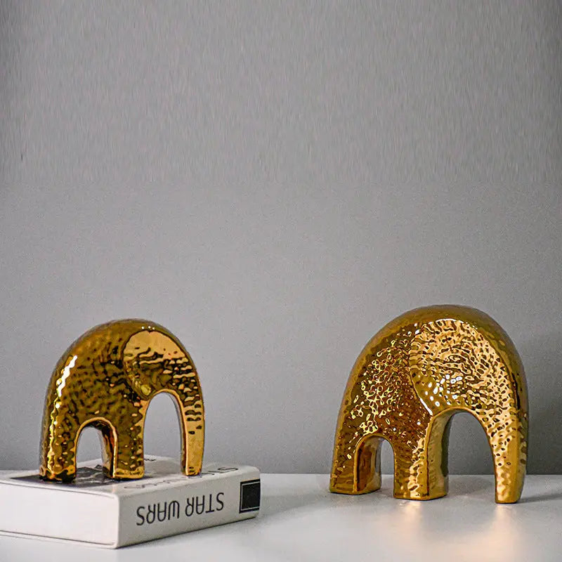 Gold-plated geometric ceramic vase in round shape on a white background