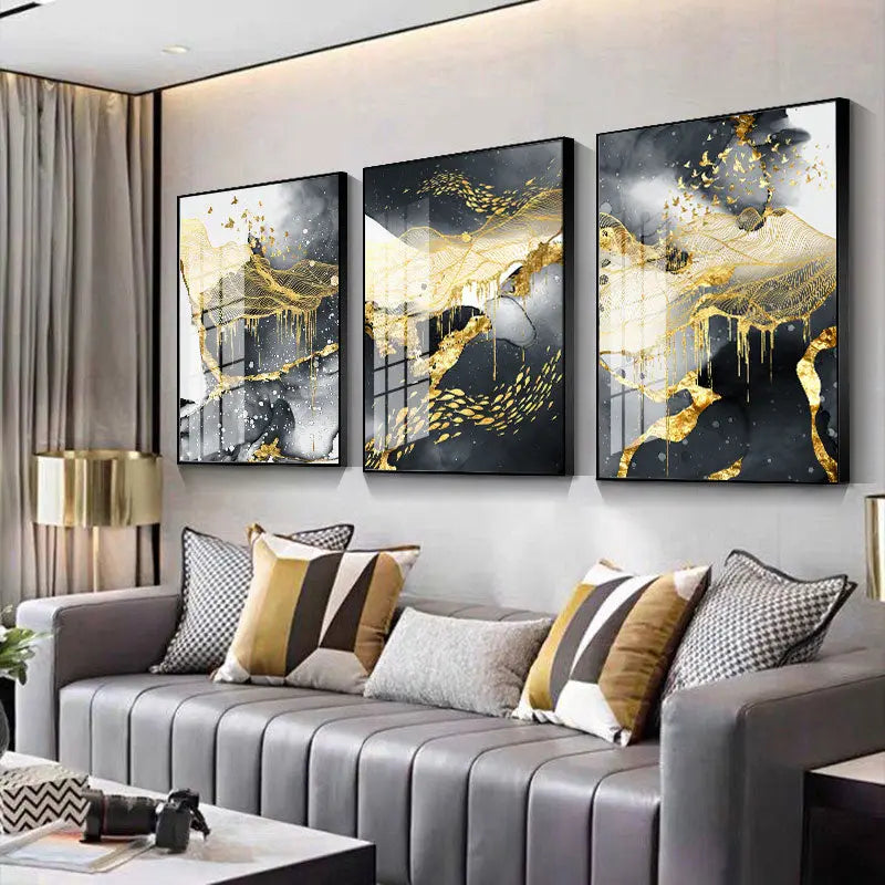 Gold, black, and white canvas wall art three-panel set displayed above a striped sofa