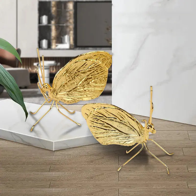 Gold butterfly decorative ornament displayed on a marble surface with dramatic lighting