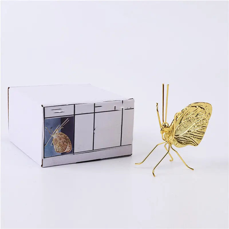 Gold butterfly decorative ornament styled on a shelf as a minimalist accent