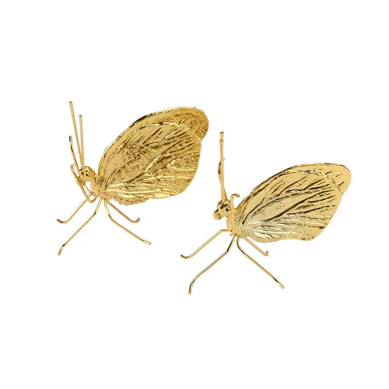 Gold butterfly decorative ornament shown on a plain white background