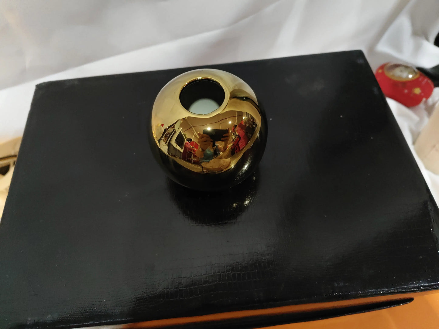 Gold electroplated ceramic vase styled on a shelf as home decor accent