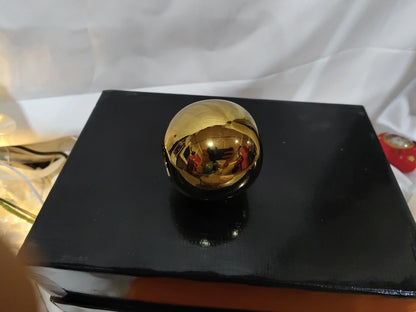 Gold electroplated ceramic vase on a black stand, alternate styling angle