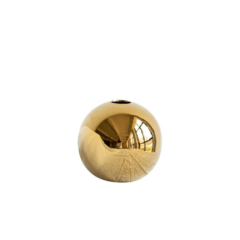 Gold electroplated ceramic vase on a plain white background