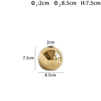 Gold electroplated ceramic vase shown with size reference for scale