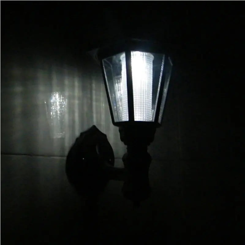 Solar hexagonal outdoor wall light glowing in a courtyard setting at night