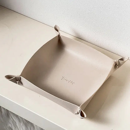 Leather storage tray in cream colorway on a desk