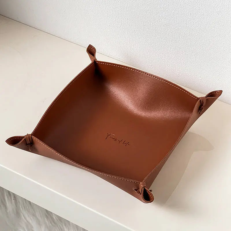 Leather storage tray in rust brown colorway on a desk
