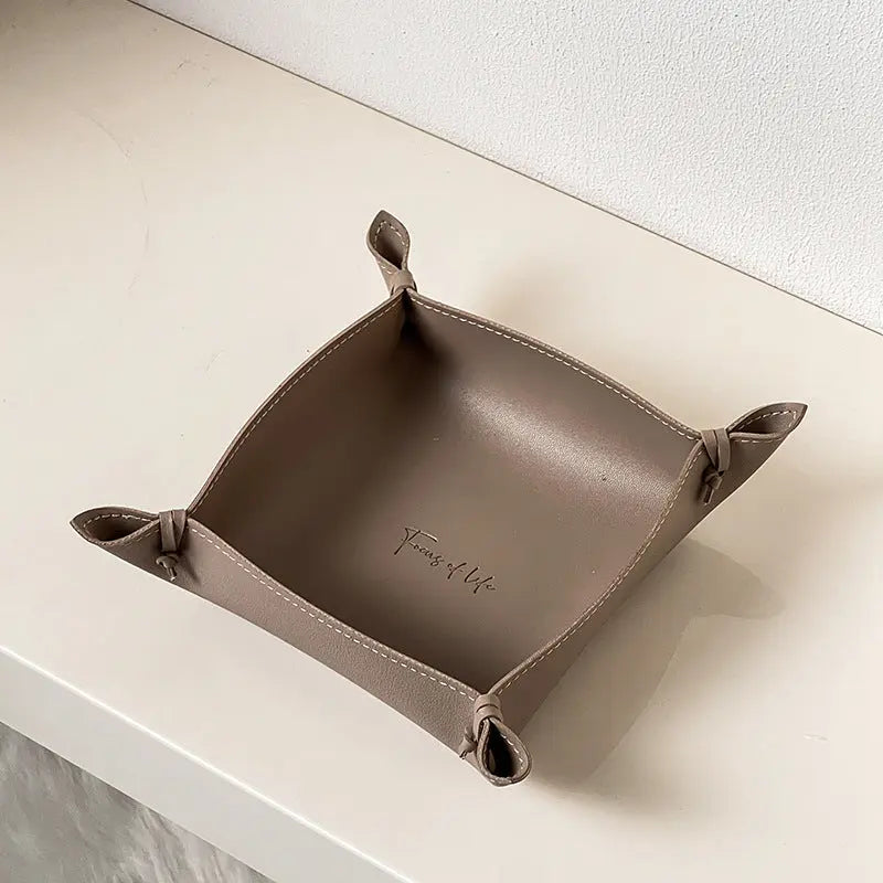 Leather storage tray in taupe colorway on a desk