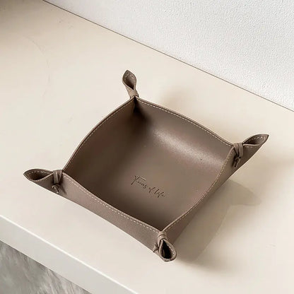 Leather storage tray in taupe colorway on a desk