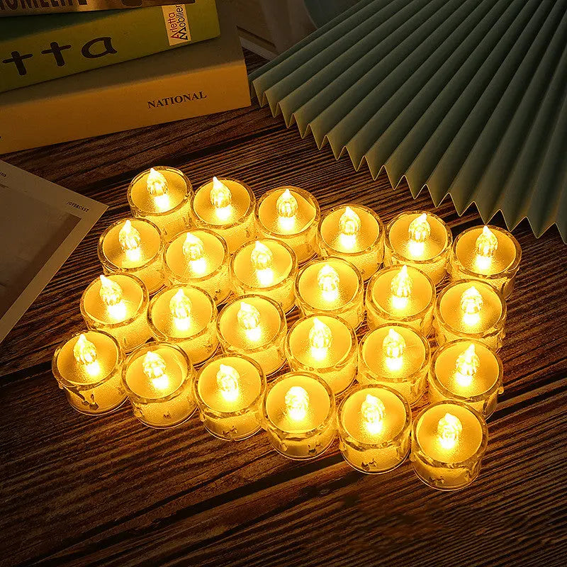 LED flameless tea light candles glowing warmly, fanned out on a stack of books