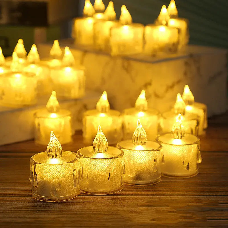 LED flameless tea light candles glowing warmly on a marble surface with books