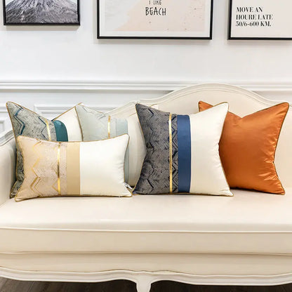 Three satin splicing cushion covers in teal, cream, and orange color combinations styled on a sofa