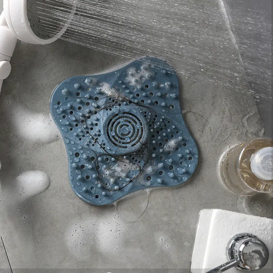 Silicone drain hair catcher in use on a shower drain with water flowing