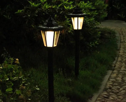 Two solar hexagonal outdoor wall lights glowing in a garden at night