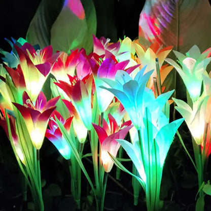 Solar lily garden stake light installed and glowing in a grassy lawn