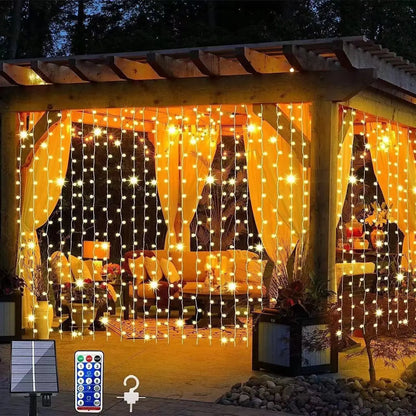 Copper wire curtain lights glowing warm white across an outdoor pergola patio at night