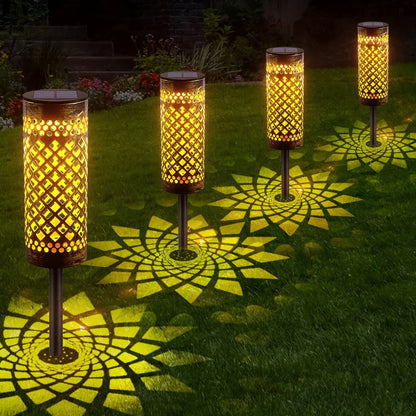 Row of waterproof solar lawn lights glowing warmly on grass at night